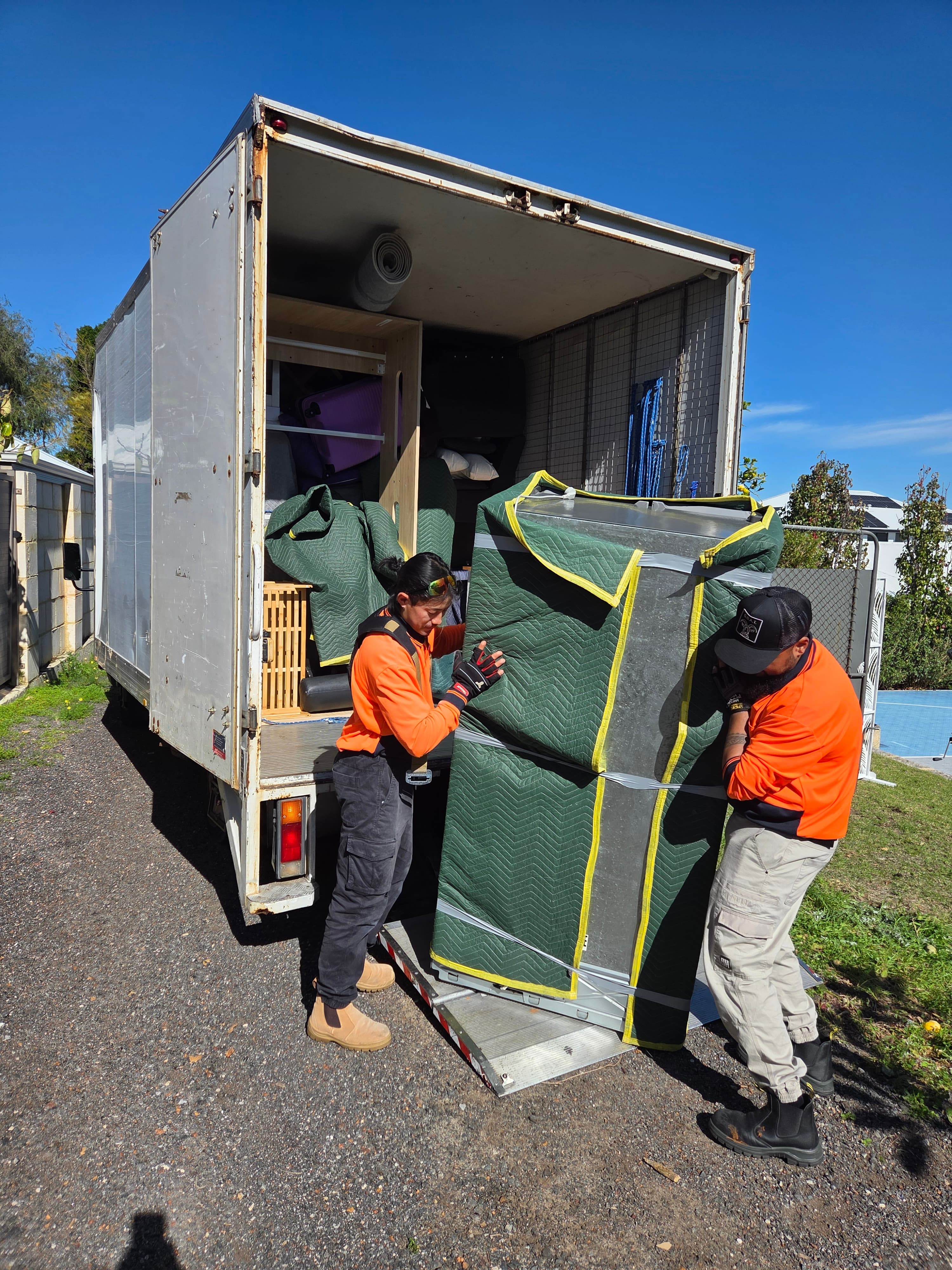 Crew moving a heavy item during a Perth removal