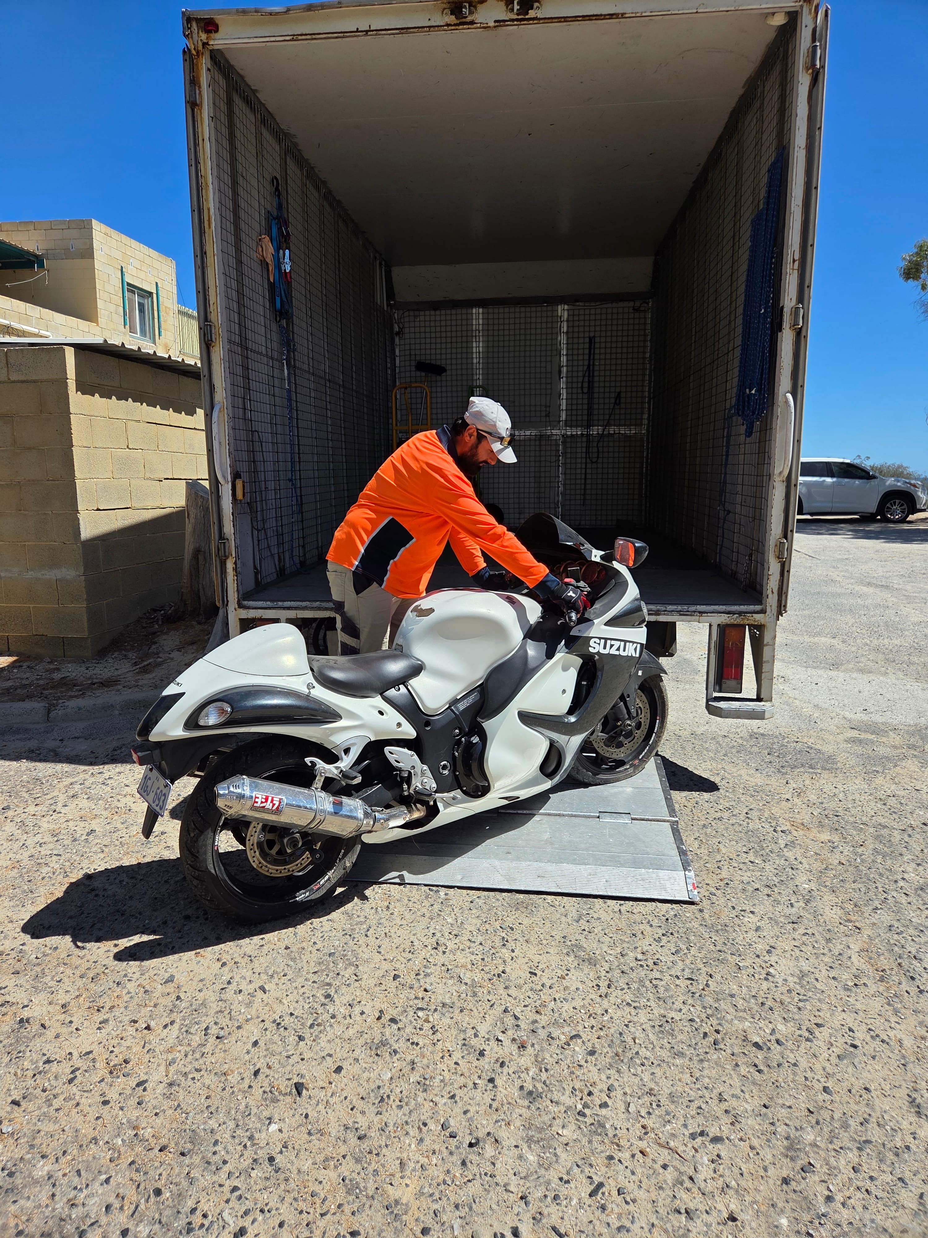 Crew loading a motorcycle onto the truck